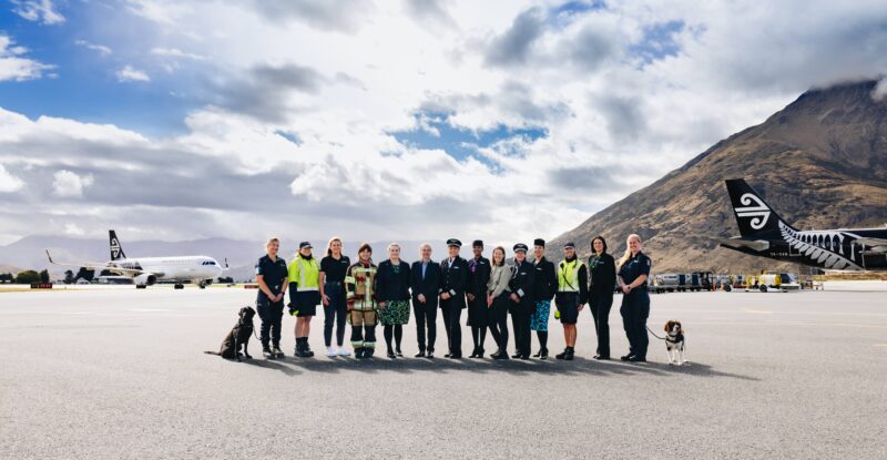 Pictured in the image from left to right: Alessandra Paladino and her dog named Darcie - EDD Officer (Dog Handler) Hanna Hyde - Aircraft Service Agent - Baggage and Baggage loading Jess Klitscher - Air Traffic Controller Tegan Stallard - AES Acting Up Crew Chief (Fire) Scarlett Meikle - Air NZ Customer Service Bridget Martin - Operations Manager - Queenstown Airport (NZ Aviation Security Service / AVSEC) Sara Mulvey - Air NZ First Officer (Pilot) Shivani Prasad - Air NZ Cabin Crew Jana Fort - Queenstown Airport Duty Manager Thyra Blaom - Air NZ Captain (Pilot) Sina Muavae - Air NZ Cabin Crew Kristal Tall - Aircraft Turn Coordinator Priscila Machado Cordeiro - Air NZ Customer Service Rosie Ulrisch & dog named Baz - EDD Officer (Dog Handler)