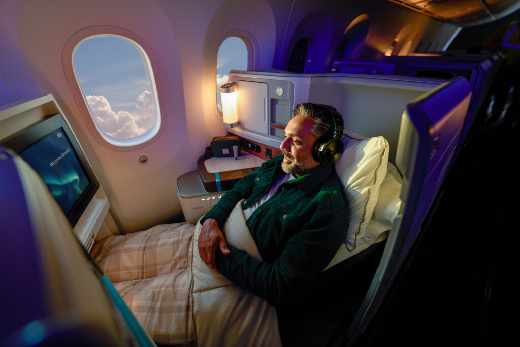 Alaska Airlines International Business Class seat is occupied by a passenger ready to sleep.