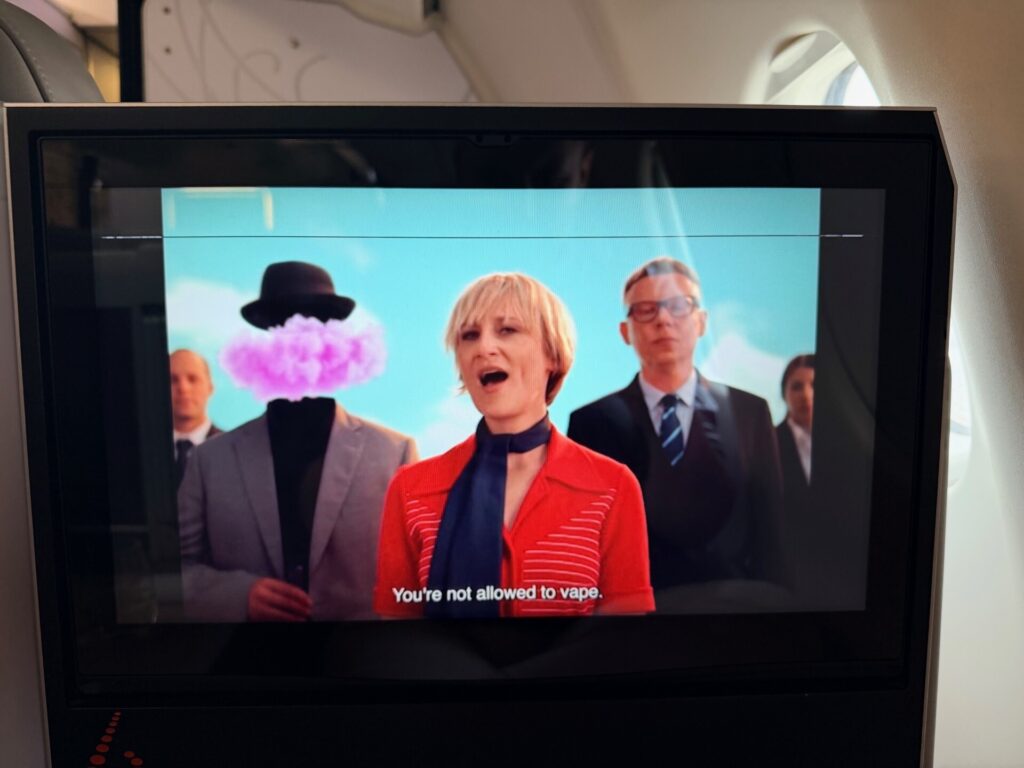 The IFE screen is playing a safety video.