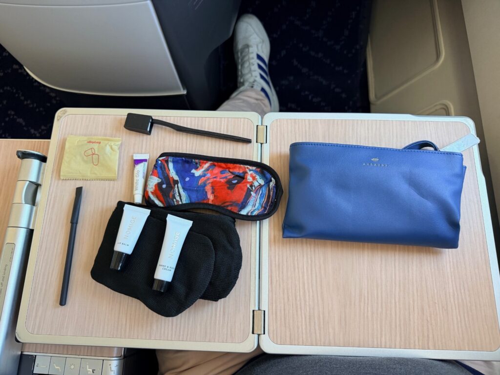 The Brussels Airlines amenity kit contents are displayed on the aircraft tray table.