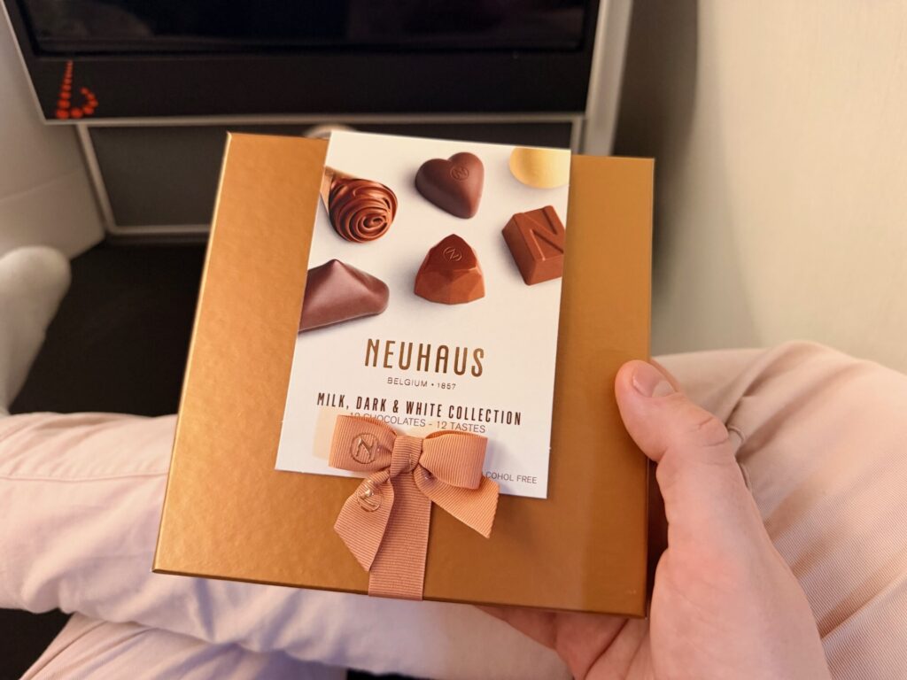 The passenger is holding up a box of chocolates.