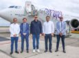 Executives stand in front of the Arajet Boeing 737 MAX 8 named “Salto de Jimenoa"
