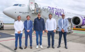 Executives stand in front of the Arajet Boeing 737 MAX 8 named “Salto de Jimenoa"