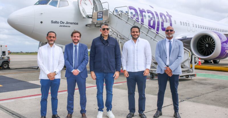 Executives stand in front of the Arajet Boeing 737 MAX 8 named “Salto de Jimenoa"