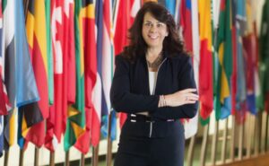 Lisa Anderson in front of the flags of the world at the UN