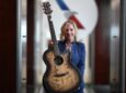 An American Airlines crew member is holding up a guitar