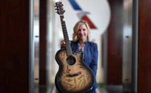 An American Airlines crew member is holding up a guitar