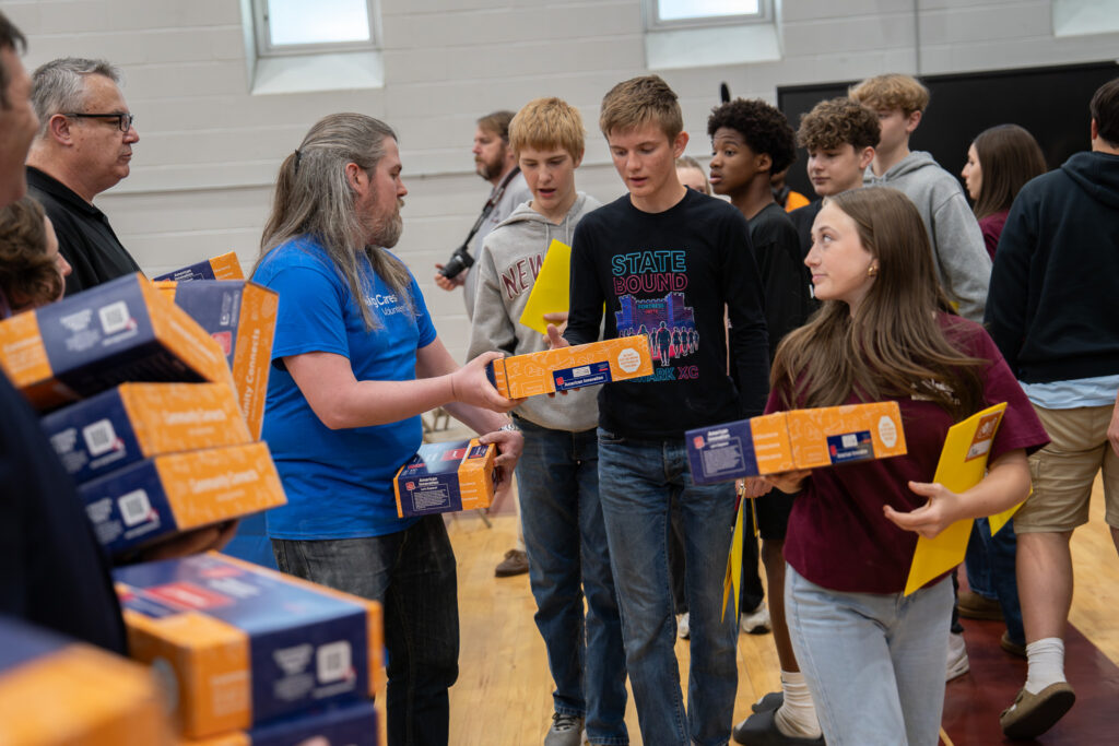 Students receive boxes of materials during a workshop