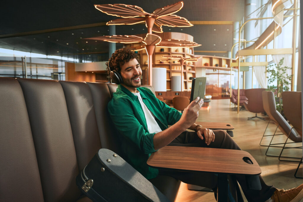 A passenger is watching content on his mobile device in the lounge.