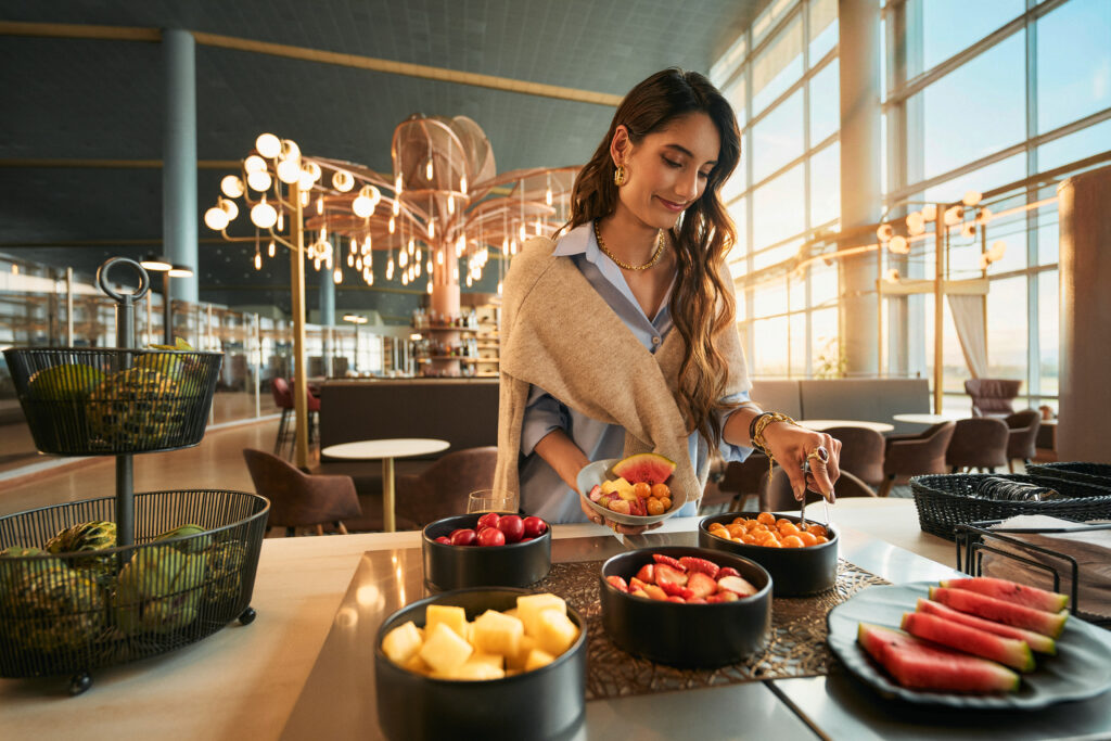 A female passenger is enjoying a meal in the Avianca Diamond International VIP lounge.
