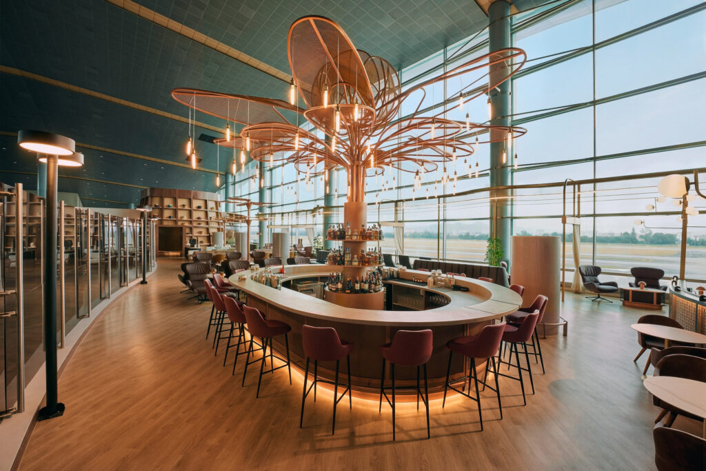 A large bar sits in the lounge. The center of the bar is a dramatic light installation.