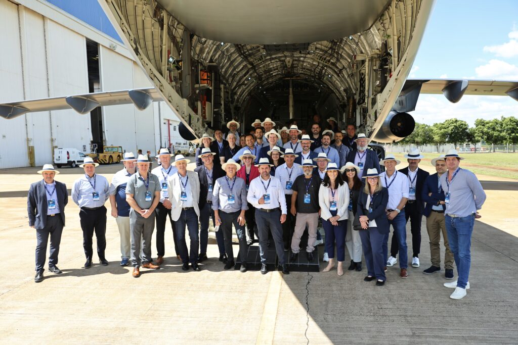 Embraer employees in front of the cargo belly of an aircraft.