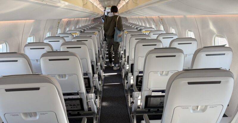 Inside the the Finnair E190 aircraft with pale, slimline seats and a very bright and airy cabin