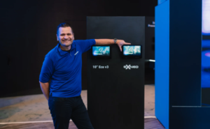 Andy Masson is standing next to the new eXNeo IFE system.