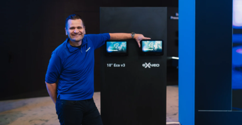 Andy Masson is standing next to the new eXNeo IFE system.