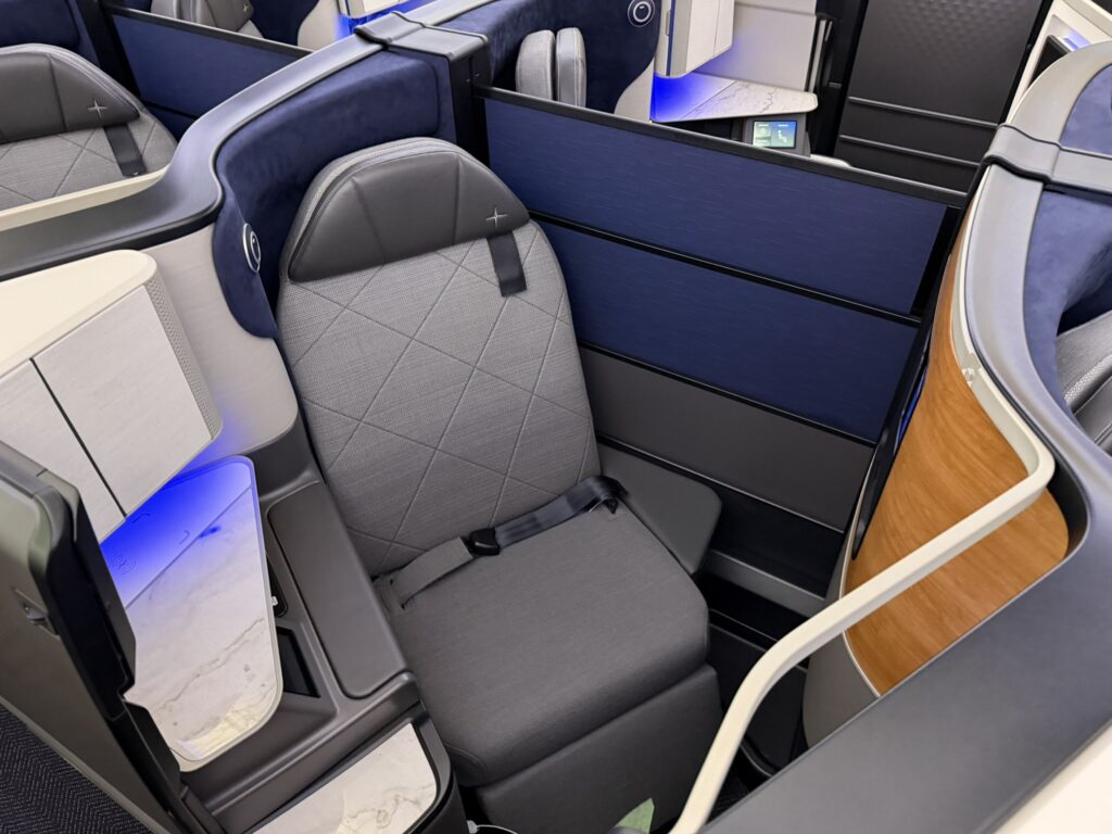 The herringbone layout requires both passengers in center pairs to push a button at the same time if they want to lower the divider.