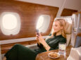 Female Passenger streaming on a mobile phone onboard an Emirates A380 using Starlink Wi‑Fi