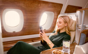 Female Passenger streaming on a mobile phone onboard an Emirates A380 using Starlink Wi‑Fi