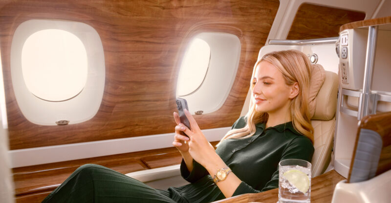 Female Passenger streaming on a mobile phone onboard an Emirates A380 using Starlink Wi‑Fi