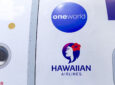 Alaska Airlines, Hawaiian Airlines and oneworld logos on the side of an aircraft