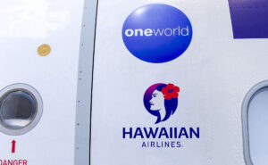 Alaska Airlines, Hawaiian Airlines and oneworld logos on the side of an aircraft