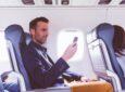 A passenger is using their mobile device in flight.