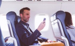 A passenger is using their mobile device in flight.