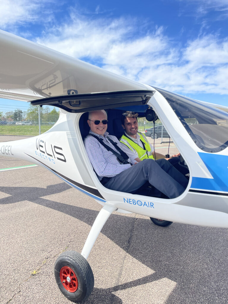Two people, including the author, Paul Eden, are seen here sitting in the Pipistrel Velis Electro by Saxon Air.