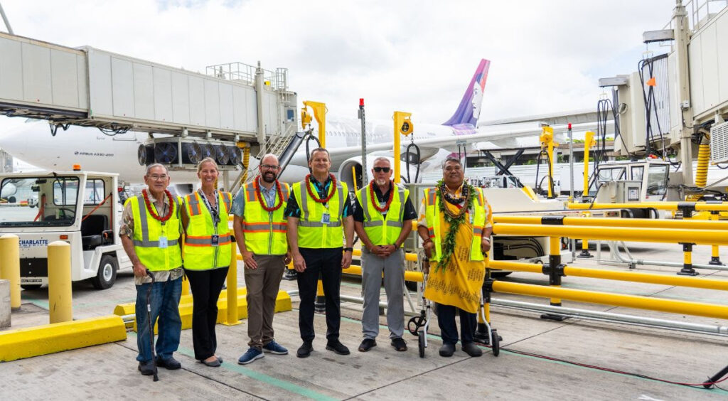Ground crew standing with the new Hawaiian Airlines electric ground support equipment.