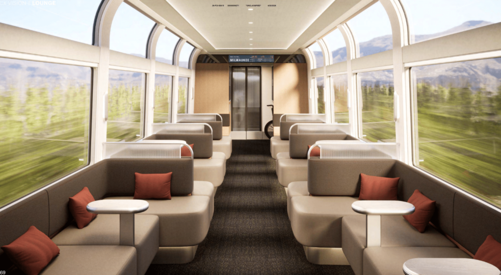 Amtrak lounge car is lit by large windows and arranged as a social space.