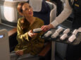 A passenger is being offered a hot towel.