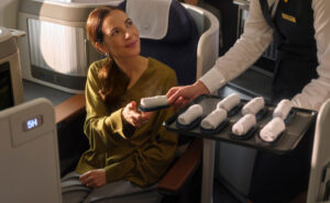 A passenger is being offered a hot towel.