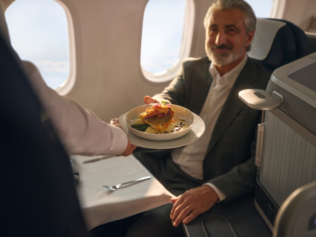 A passenger is being handed a meal in flight. 