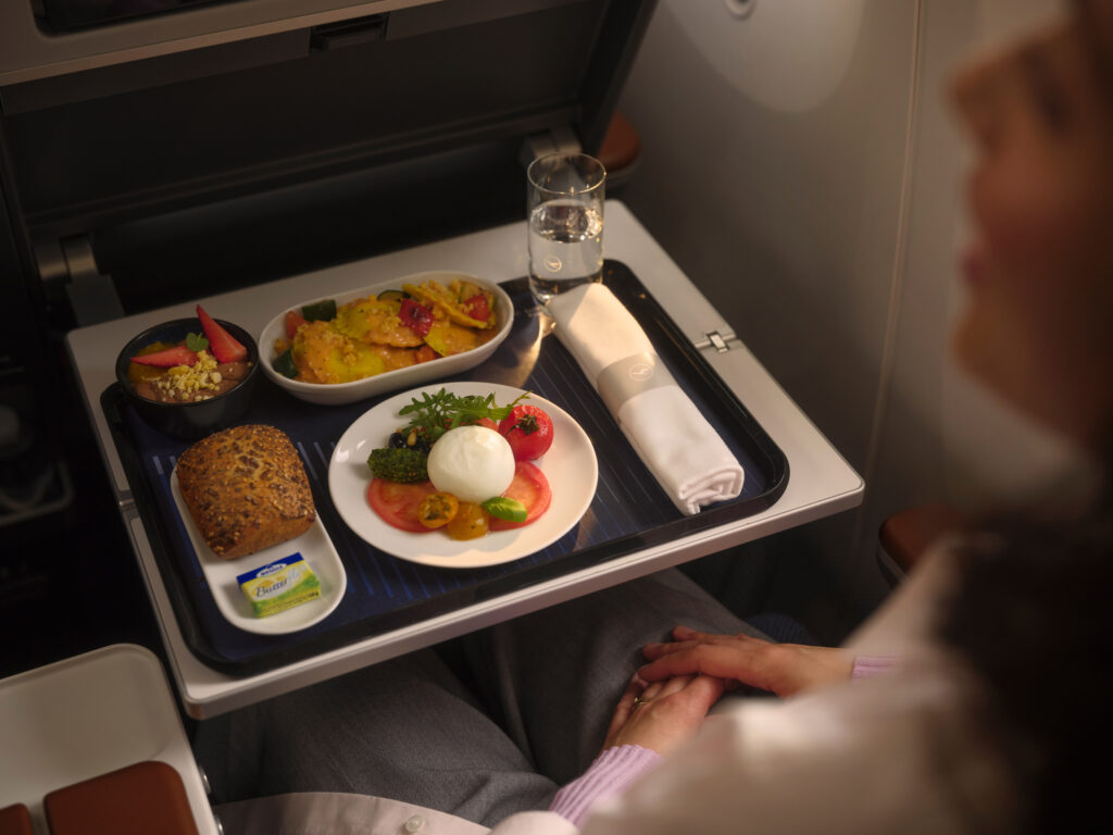 A passenger is served a meal in flight. 