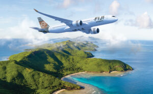 Fiji Airways aircraft in flight over an island.