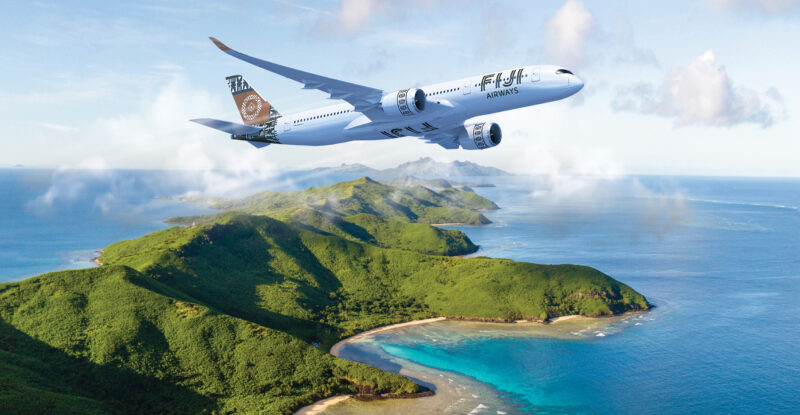 Fiji Airways aircraft in flight over an island.