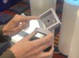 A woman holds up the tiny Iridium PNC ASIC