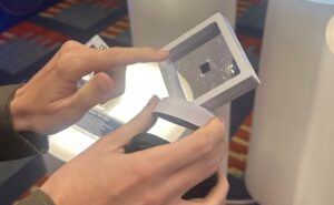 A woman holds up the tiny Iridium PNC ASIC
