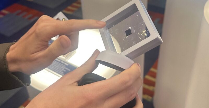 A woman holds up the tiny Iridium PNC ASIC