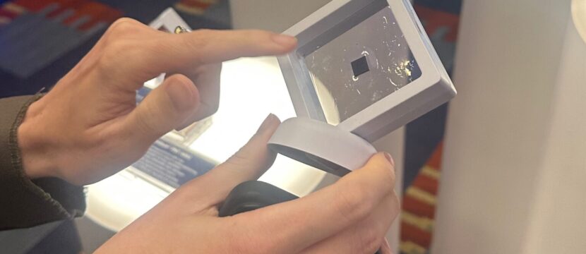 A woman holds up the tiny Iridium PNC ASIC