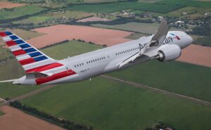 American Airlines aircraft in flight over a farm field.