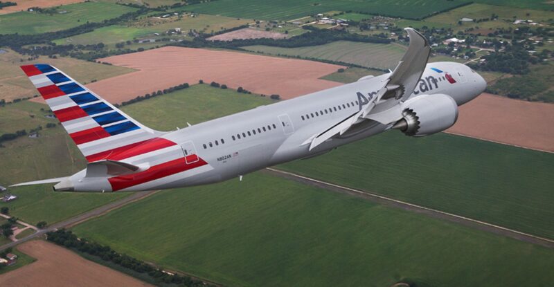 American Airlines aircraft in flight over a farm field.