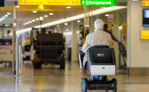 An elderly man uses the WHILL Autonomous Service at Heathrow Airport Terminal 3.