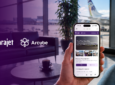 Arajet and Arcube logos over an airport lounge. A passenger is holding up a mobile device.