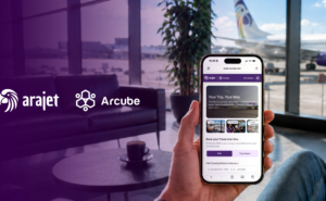 Arajet and Arcube logos over an airport lounge. A passenger is holding up a mobile device.