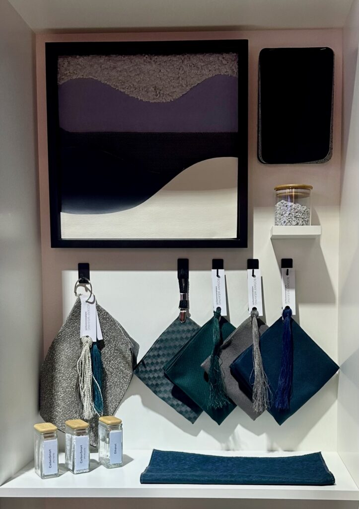 Wet blue shavings are seen in a jar on Boeing's stand. Below them are different swatches of material.