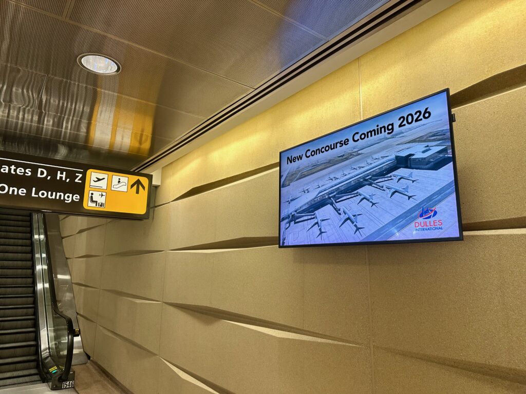Large screen at Dulles touts the new concourse "coming 2026"