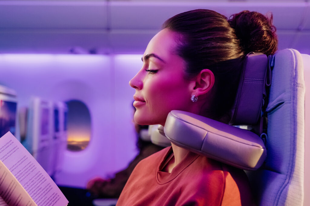A woman enjoys using the Emirates U-Dream Headrest