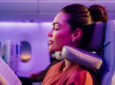A woman passenger enjoys using the Emirates U-Dream Headrest