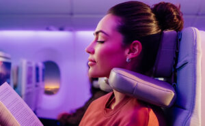 A woman passenger enjoys using the Emirates U-Dream Headrest